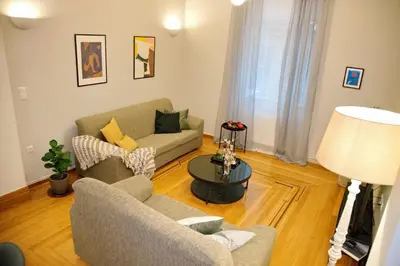 a living room with two couches and a table at Aroura Neoclassical Home 3BR 2BA in Athens
