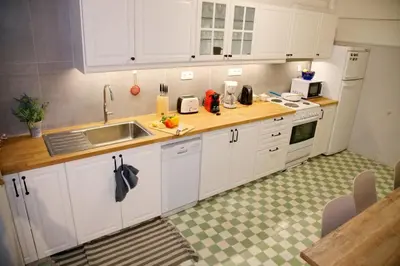 a kitchen with white cabinets and a sink at Aroura Neoclassical Home 3BR 2BA in Athens