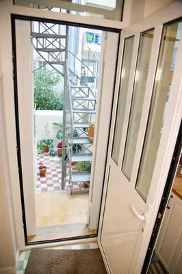 an open door leading to a staircase with plants at Aroura Neoclassical Home 3BR 2BA in Athens