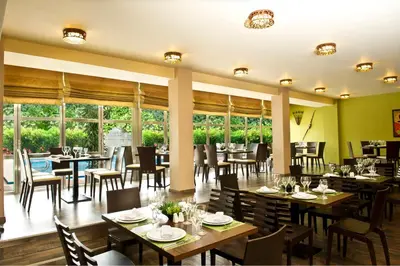 a restaurant with tables and chairs and windows at Congo Palace in Athens