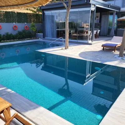a swimming pool with blue water in a house at Stergiou Luxury Apartments with shared pool in Anavissos