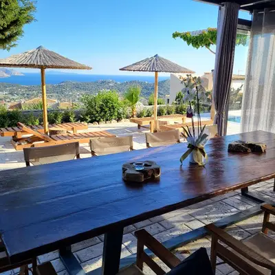 a wooden table with a view of the ocean at Stergiou Luxury Apartments with shared pool in Anavissos