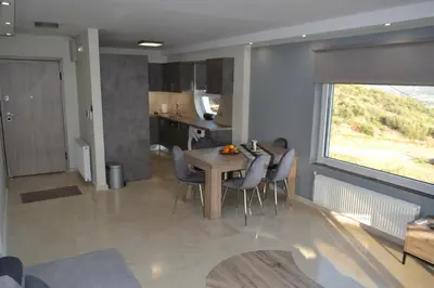 a kitchen and dining room with a table and chairs at Stergiou Luxury Apartments with shared pool in Anavissos