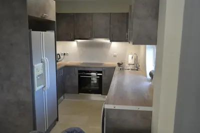 a kitchen with wooden cabinets and a refrigerator at Stergiou Luxury Apartments with shared pool in Anavissos
