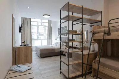 a room with a bed and a room with bunk beds at Piraeus City Hotel in Piraeus