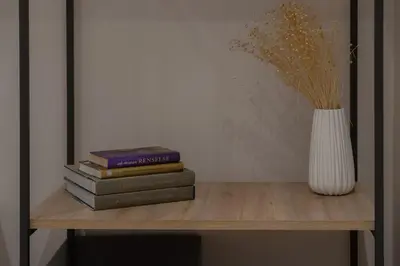 a stack of books sitting on a table with a vase at Piraeus City Hotel in Piraeus