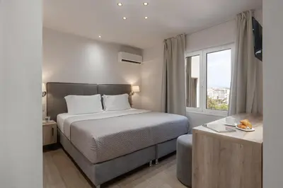 a hotel room with a bed and a window at Piraeus City Hotel in Piraeus