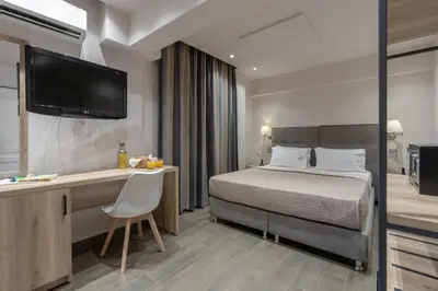 a hotel room with a bed and a desk and a television at Piraeus City Hotel in Piraeus