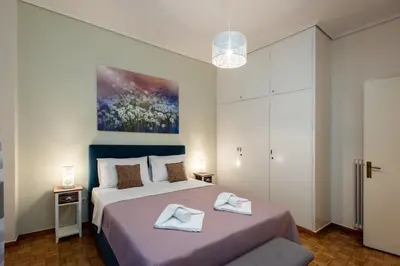 a bedroom with a bed with two towels on it at Blue Ark Gate to History in Athens