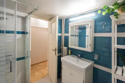a bathroom with a sink and a mirror and a shower at Blue Ark Gate to History in Athens