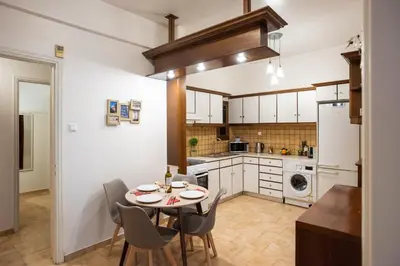 a kitchen with a table and chairs in a room at Blue Ark Gate to History in Athens