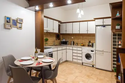 a kitchen with a table and chairs in a room at Blue Ark Gate to History in Athens
