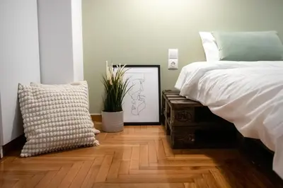 a bedroom with a bed and a picture on a wooden floor at Apartment 7 in Athens
