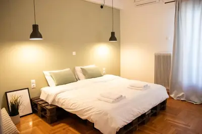 a bedroom with a large white bed with two towels on it at Apartment 7 in Athens