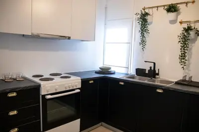 a kitchen with black cabinets and a stove and a sink at Apartment 7 in Athens