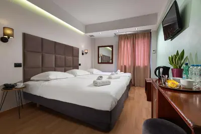a hotel room with a large bed and a desk at Athens Odeon Hotel in Athens
