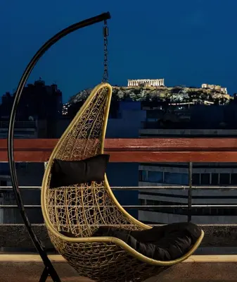 a rattan hammock hanging from a pole on a building at Athens Odeon Hotel in Athens