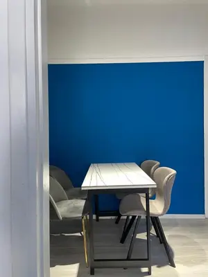 a table and chairs in a room with a blue wall at uoohome7 garden one bedroom in Athens