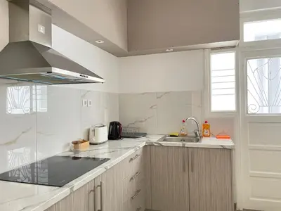 a white kitchen with a sink and a stove at uoohome7 garden one bedroom in Athens