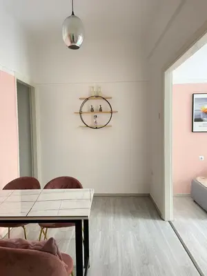 a dining room with a table and a clock on the wall at uoohome7 garden one bedroom in Athens