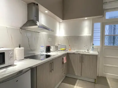 a white kitchen with a sink and a microwave at uoohome7 garden one bedroom in Athens
