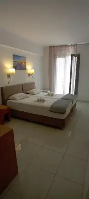 a bedroom with two beds and a window at Delfini Hotel in Piraeus