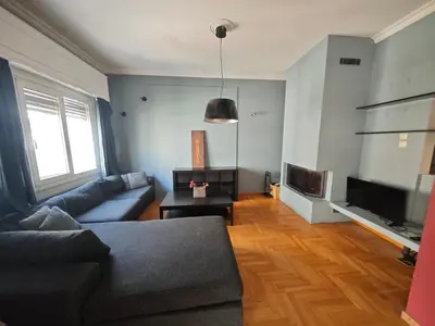 a living room with a couch and a tv at Exarchia Square central Athens 110m2 apartment in Athens