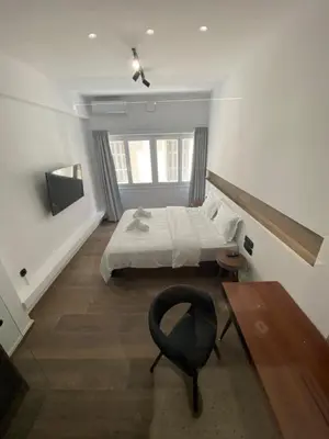 a bedroom with a bed and a desk and a chair at Athens Center Boutique Suites in Athens