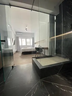 a bathroom with a glass shower and a bedroom at Athens Center Boutique Suites in Athens