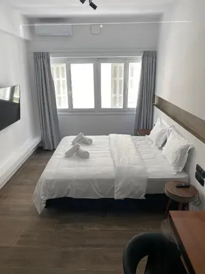 a bedroom with a large bed with two towels on it at Athens Center Boutique Suites in Athens