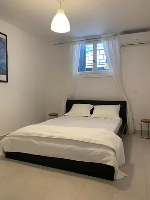 a bedroom with a large bed with a window at Modern 3BR Maisonette with garden 10 min from Acropolis in Athens