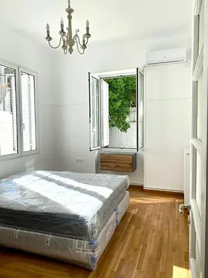 a bedroom with a bed in a room with windows at Modern 3BR Maisonette with garden 10 min from Acropolis in Athens