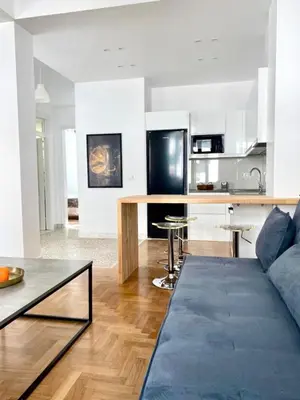 a living room with a couch and a kitchen at Modern 3BR Maisonette with garden 10 min from Acropolis in Athens