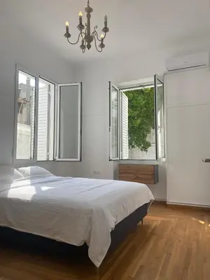 a bedroom with a large bed and two windows at Modern 3BR Maisonette with garden 10 min from Acropolis in Athens