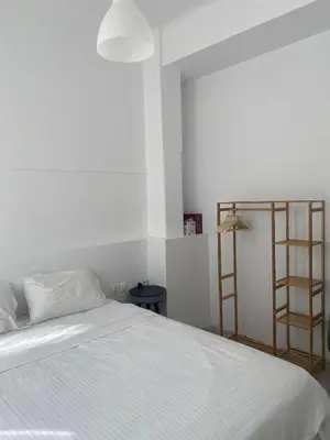 a bedroom with a white bed and a ladder at Modern 3BR Maisonette with garden 10 min from Acropolis in Athens