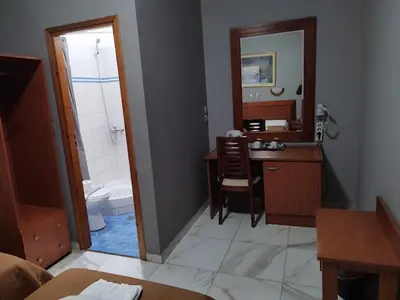a bathroom with a vanity and a sink and a mirror at Piraeus Acropole Hotel in Piraeus