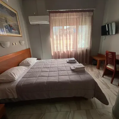 a bedroom with a large bed and a window at Piraeus Acropole Hotel in Piraeus