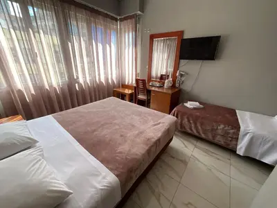 a hotel room with two beds and a mirror at Piraeus Acropole Hotel in Piraeus