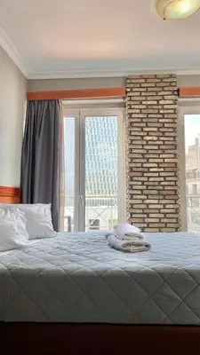 a bedroom with a bed and a large window at Piraeus Acropole Hotel in Piraeus