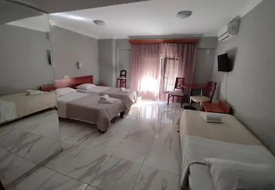 a hotel room with two beds and a window at Piraeus Acropole Hotel in Piraeus