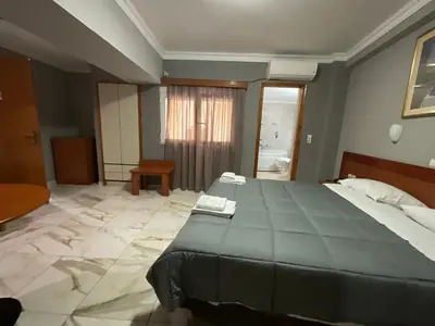 a bedroom with a large bed and a bathroom at Piraeus Acropole Hotel in Piraeus