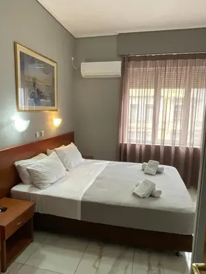 a bedroom with a bed with two towels on it at Piraeus Acropole Hotel in Piraeus