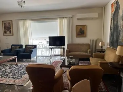a living room with a couch and chairs and a tv at Spacious and sunny appartment in Cholargos in Athens