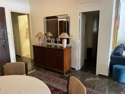 a living room with a table and a mirror at Spacious and sunny appartment in Cholargos in Athens