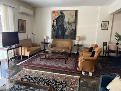 a living room with couches and a flat screen tv at Spacious and sunny appartment in Cholargos in Athens