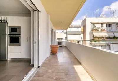a large white kitchen with a balcony with a view at Pratinou Penthouse in Athens