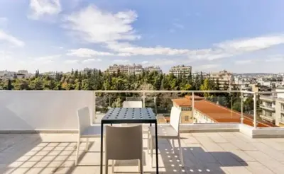 a patio with a table and chairs on a balcony at Pratinou Penthouse in Athens