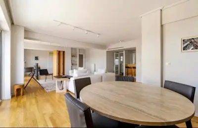 a living room with a wooden table and a dining room at Pratinou Penthouse in Athens
