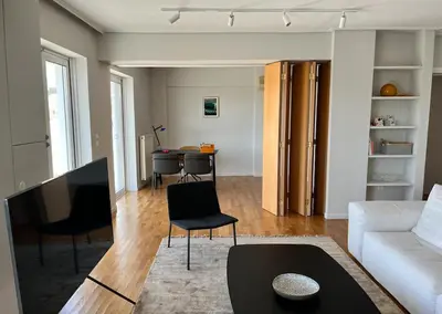 a living room with a white couch and a table at Pratinou Penthouse in Athens