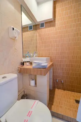 a bathroom with a toilet and a sink and a mirror at Palace Hotel Glyfada in Athens